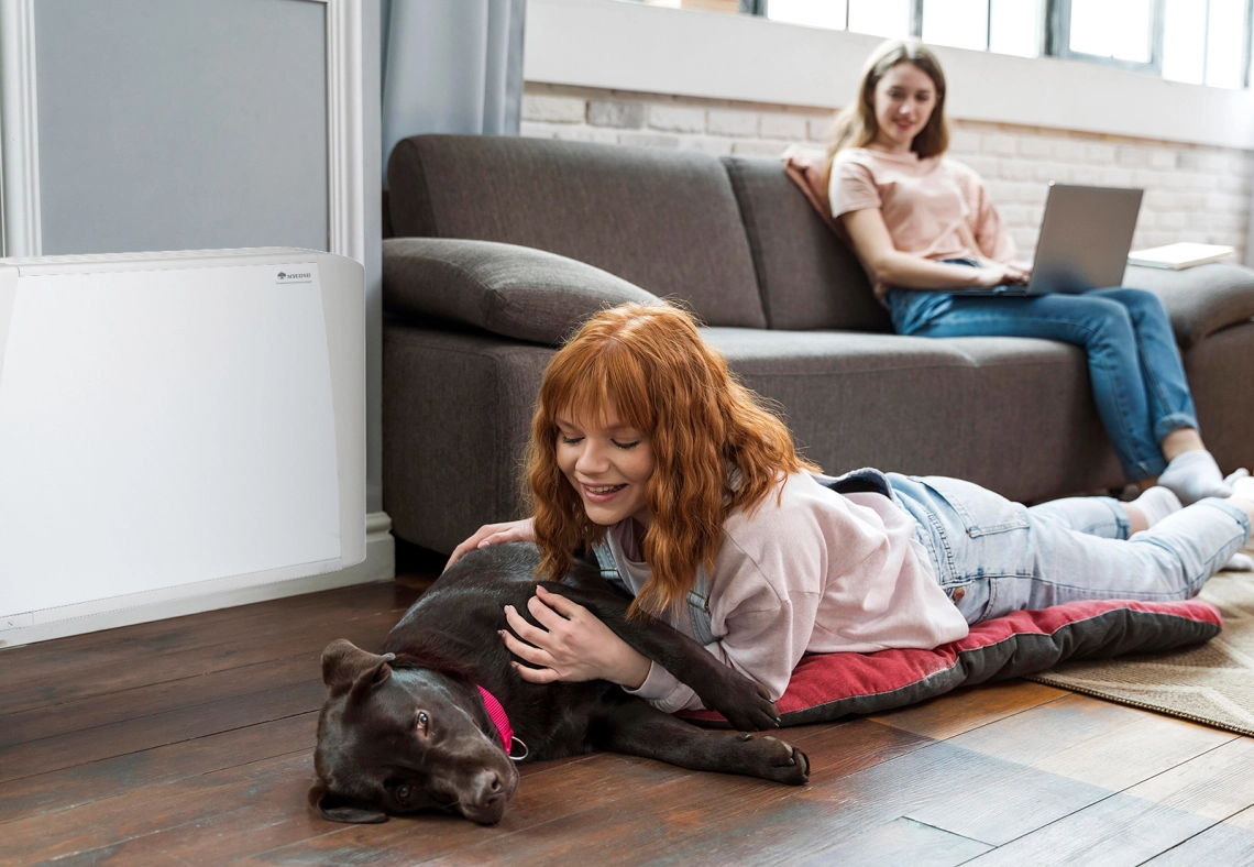 MyCond SEC/F Een meisje en haar hond naast een ventilatorconvector.